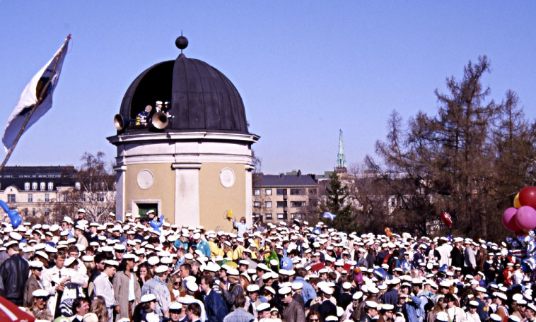 Suuri joukko ihmisiä ylioppilaslakeissa Ullanlinnanmäen observatorion ympärillä.