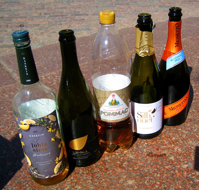 Jonossa pulloja graniittitasolla: juhlasima, Finna-kuohuva, Pommac, Silhouet-kuohuva ja Mionetto-kuohuva.
